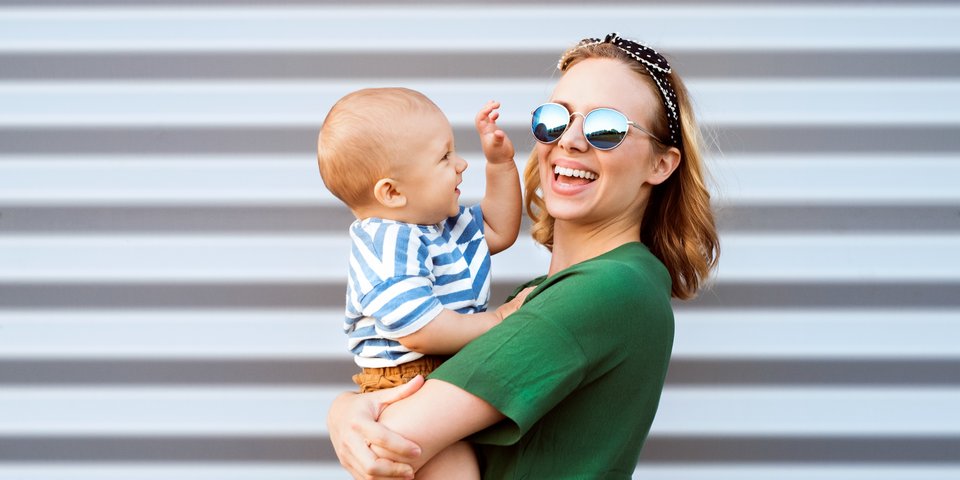 Junge Frau mit Kind auf dem Arm